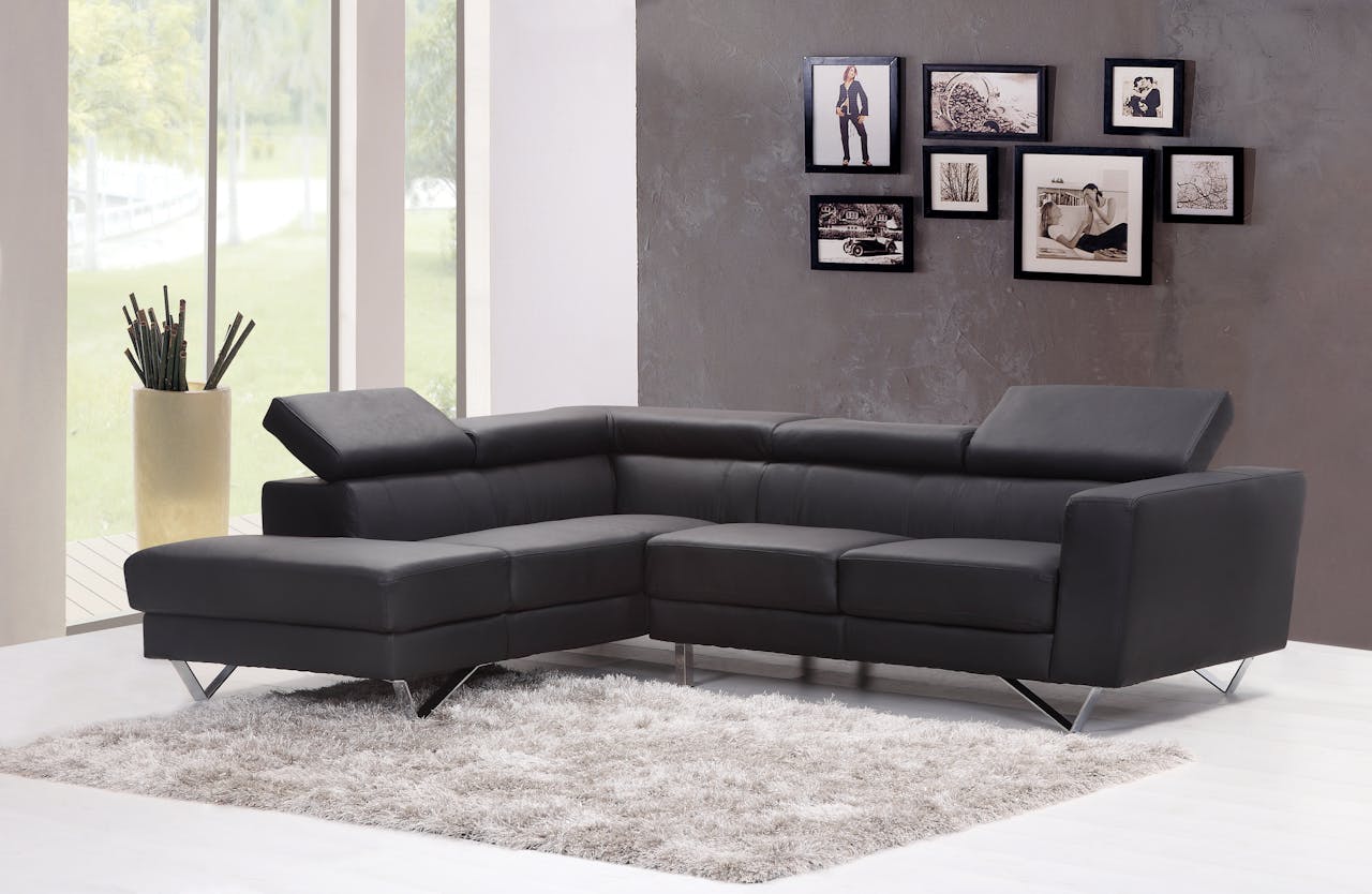 gallery-04 Contemporary living room featuring a sleek black sectional sofa and chic wall art.