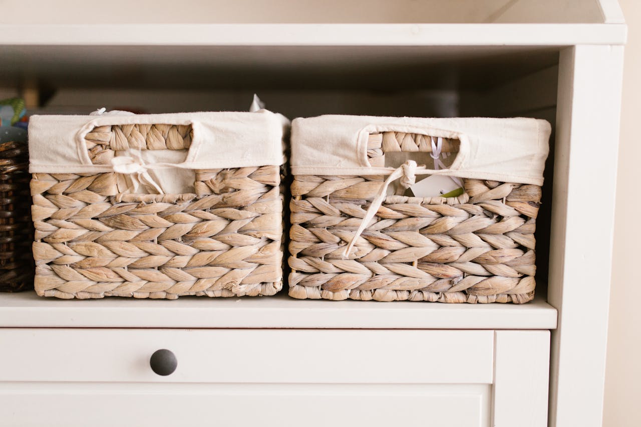 gallery-01 Stylish woven baskets neatly arranged on a white shelf for home organization solutions.